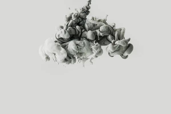 Vue rapprochée de la fumée ou mélange de peintures gris clair et noires éclaboussures dans l'eau isolée sur gris — Photo de stock