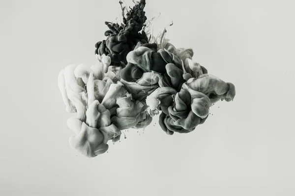 Крупным планом смешивания светло-серых и черных красок брызги в воде изолированы на сером — стоковое фото