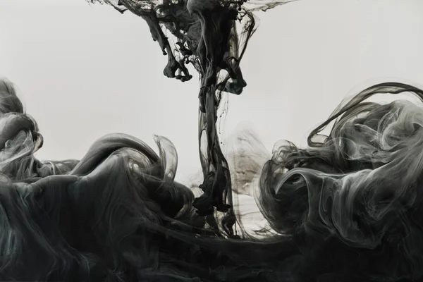 Nahaufnahme der Mischung von hellgrauer und schwarzer Tinte in Wasser isoliert auf grau — Stockfoto