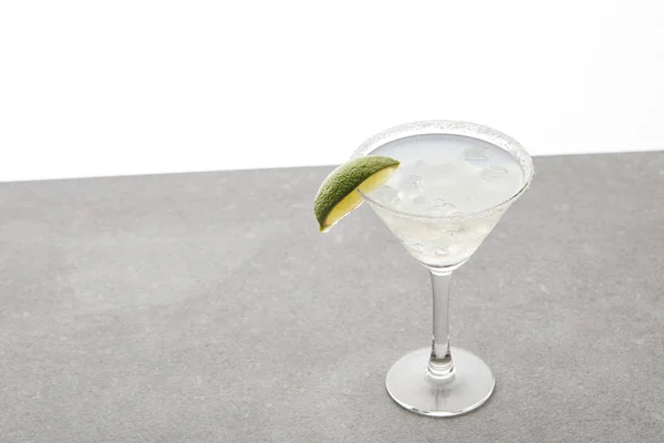 Vista da vicino di rinfrescante cocktail di margarita alcolica con lime e ghiaccio su tavolo su bianco — Foto stock