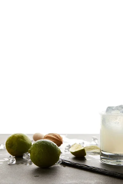 Close up view of refreshing sour caipirinha cocktail with lime on tabletop on white — Stock Photo