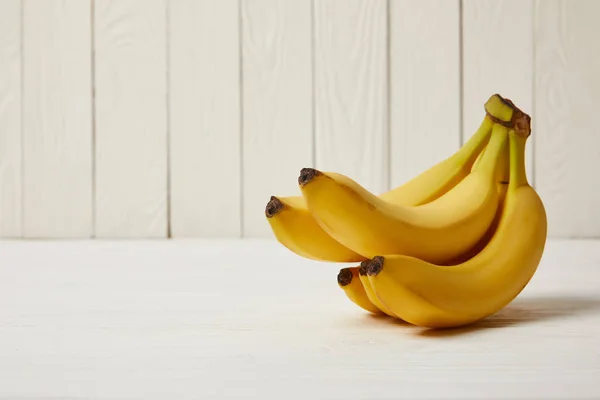 Bananas amarelas orgânicas cruas em fundo de madeira com espaço de cópia — Fotografia de Stock