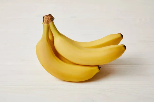 Сырые свежие желтые бананы на деревянном фоне — стоковое фото
