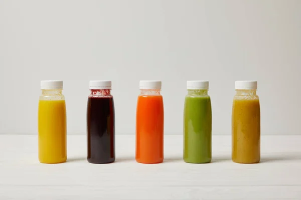 Smoothies de désintoxication en bouteilles debout dans la rangée, concept de rafraîchissement — Photo de stock