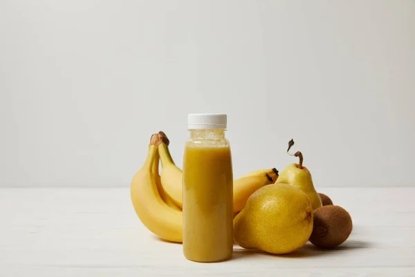 Smoothie amarelo com bananas, kiwis e peras sobre fundo branco — Fotografia de Stock