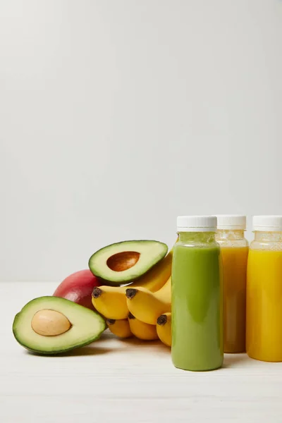 Frutas frescas de desintoxicación y batidos en botellas sobre fondo blanco - foto de stock