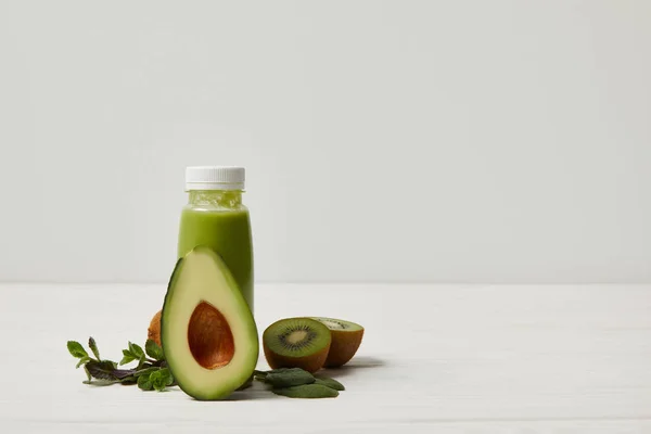 Smoothie com abacate verde, kiwi e hortelã na superfície de madeira branca — Fotografia de Stock