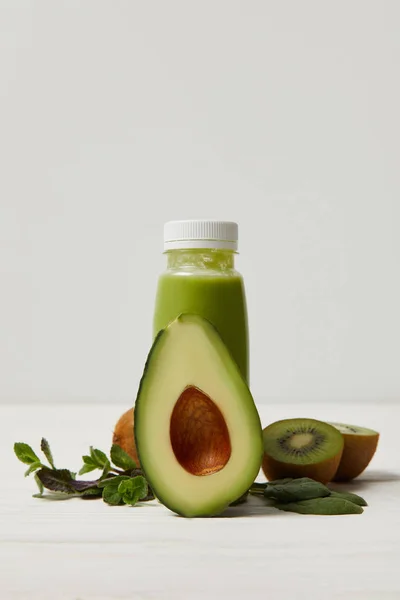 Green detox smoothie with avocado, kiwi and mint on white wooden surface — Stock Photo