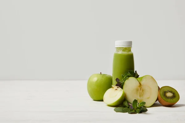 Smoothie desintoxicação verde com maçãs, kiwi e hortelã e na superfície de madeira branca — Fotografia de Stock