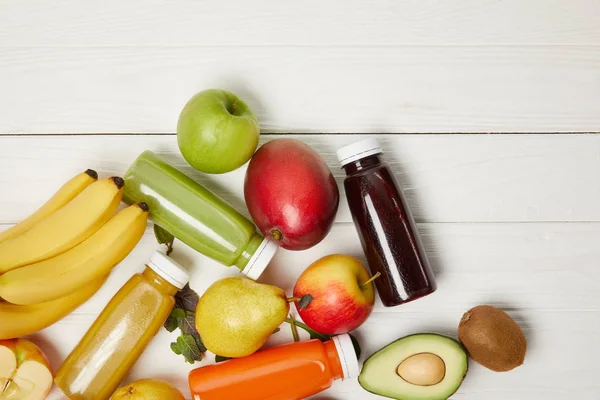 Vue de dessus des fruits frais et smoothies sur fond de bois blanc avec espace de copie — Photo de stock