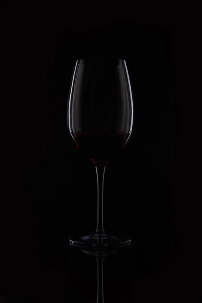 Nahaufnahme von Glas mit Rotwein isoliert auf schwarzem Hintergrund — Stockfoto