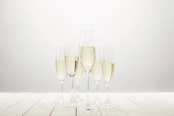 Closeup view of champagne glasses on white wooden table — Stock Photo