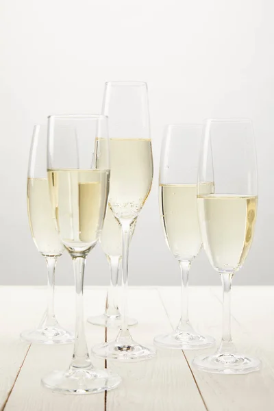 Closeup view of champagne glasses on white wooden table — Stock Photo