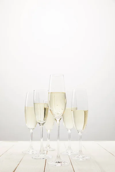 Closeup view of champagne glasses on white wooden table — Stock Photo