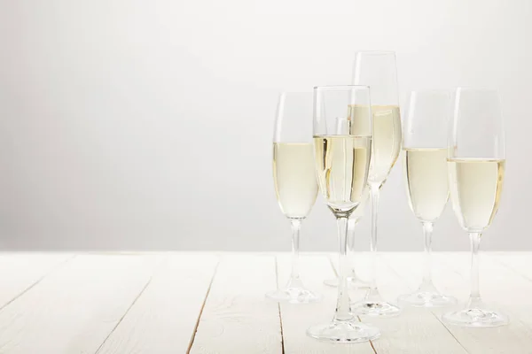 Closeup shot of champagne glasses on white wooden table — Stock Photo