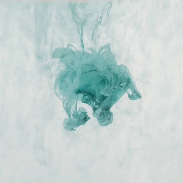 Художественный всплеск бирюзовой краски в воде — стоковое фото