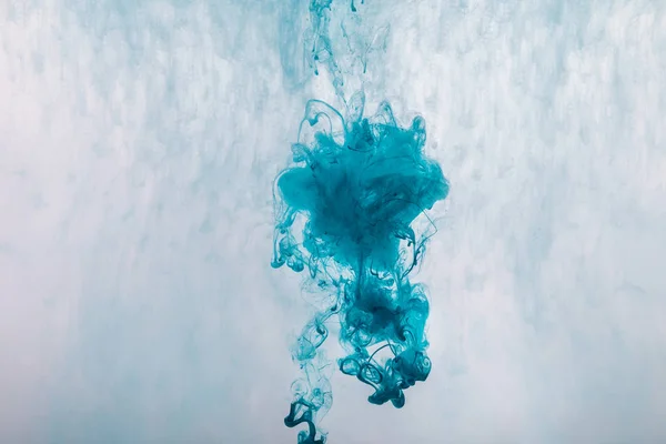 Diseño creativo con salpicaduras de pintura azul en el agua - foto de stock