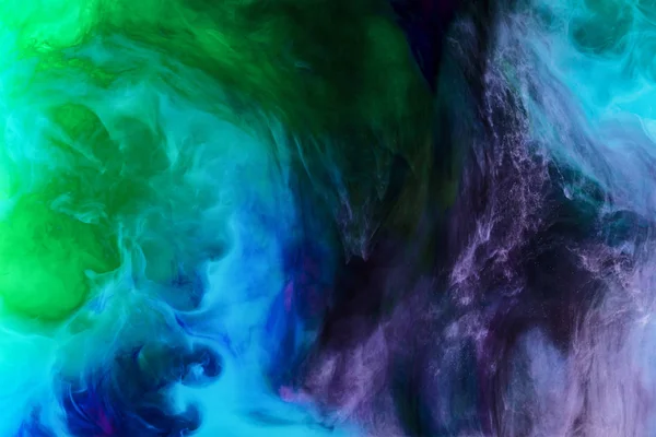 Творческий фон с синим, фиолетовым и зеленым вихрями краски выглядит как пространство — стоковое фото