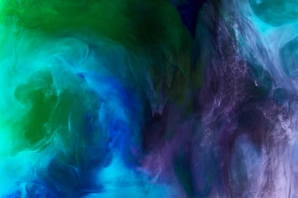 Fond créatif avec de la peinture à l'aquarelle violette, bleue et verte dans l'eau comme espace — Photo de stock