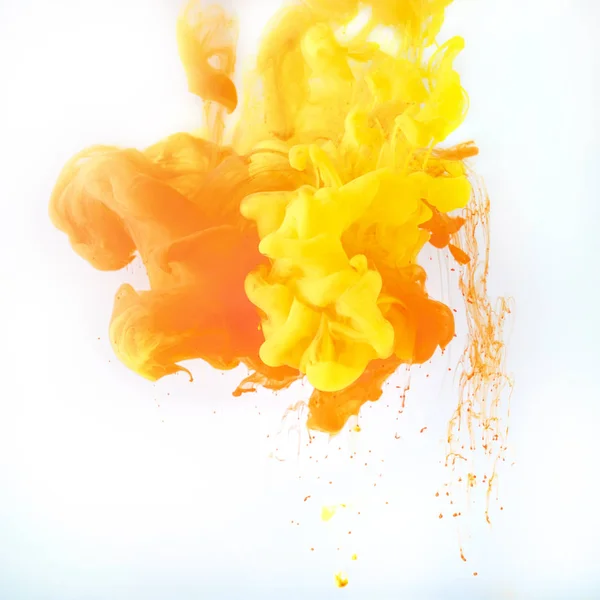 Textura con salpicaduras de pintura amarilla y naranja, aisladas en blanco - foto de stock
