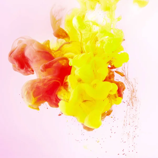 Textura con fluidos remolinos de pintura amarilla y roja en rosa - foto de stock