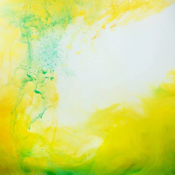 Fond abstrait avec de la peinture verte et jaune coulant dans l'eau — Photo de stock