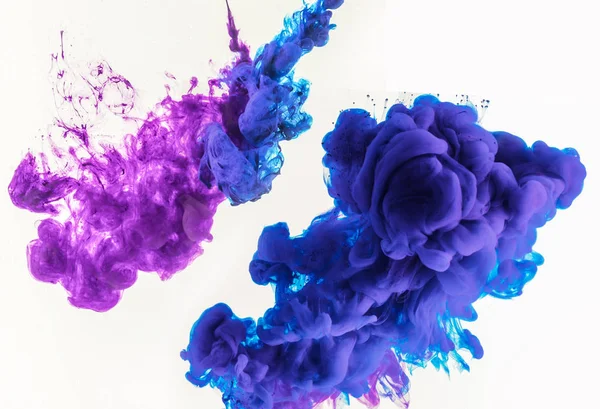 Design abstrait avec des éclaboussures fumées de peinture bleue et violette dans l'eau, isolé sur blanc — Photo de stock