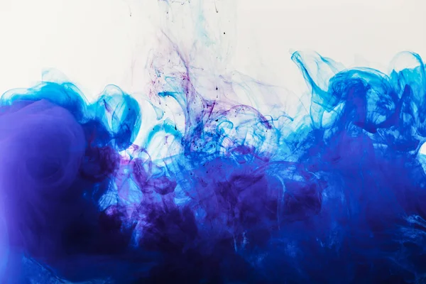 Artistic background with blue and purple paint mixing in water — Stock Photo