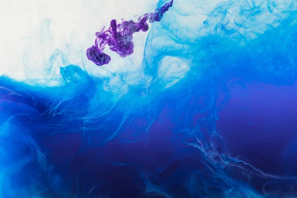 Blue and purple paint mixing in water — Stock Photo