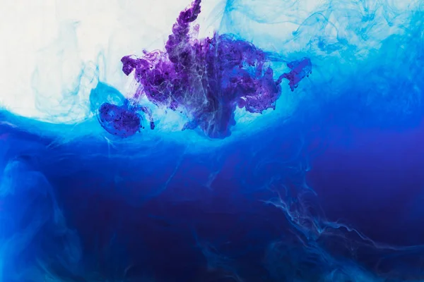 Fond abstrait avec de la peinture bleue et violette coulant dans l'eau — Photo de stock