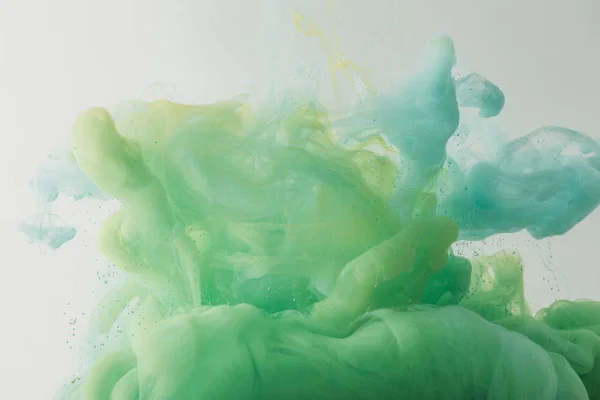Textura ligera con turquesa fluida y pintura verde en agua, aislada en gris - foto de stock