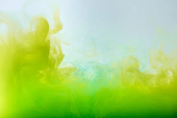 Fundo abstrato com tinta guache verde e amarelo fluente em água — Fotografia de Stock