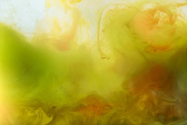 Fond artistique avec peinture jaune et orange fluide — Photo de stock
