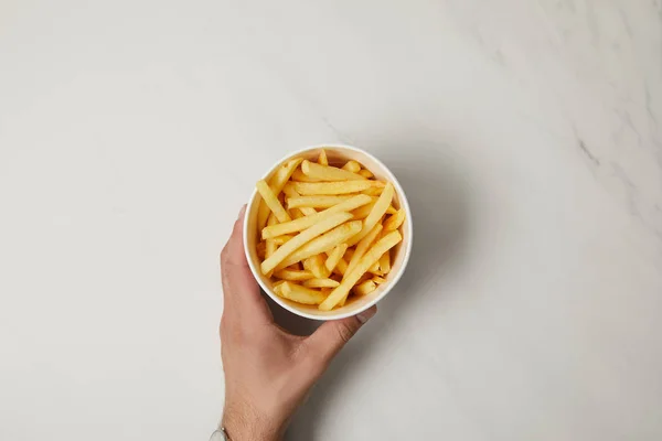 Cropped shot of man holding bowl of delicious french fries on white — Stock Photo