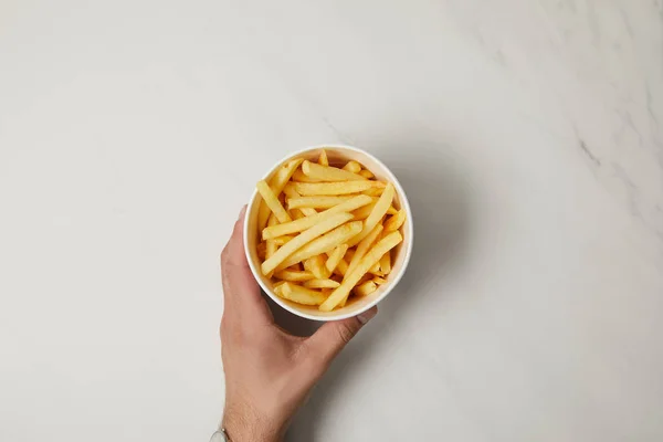 Plan recadré de l'homme tenant bol de délicieuses frites sur blanc — Photo de stock