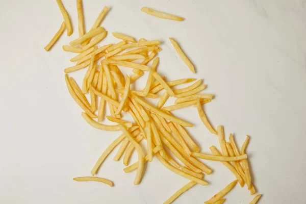 Vue de dessus des frites déversées sur la surface blanche — Photo de stock