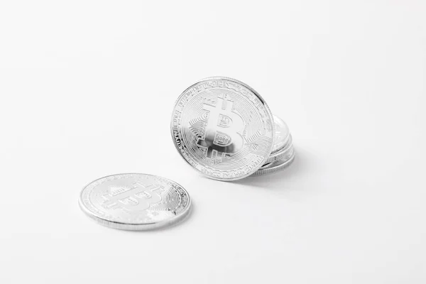 Крупный план серебряных биткоинов на белом столе — стоковое фото