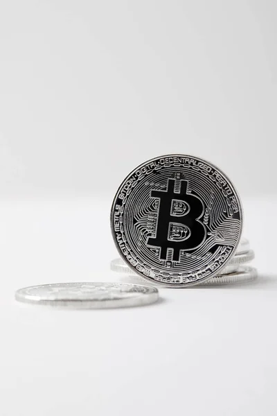 Primer plano de Bitcoin de pie sobre la mesa blanca - foto de stock