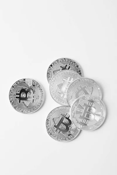 Draufsicht auf einen Haufen Bitcoins auf weißer Oberfläche — Stockfoto