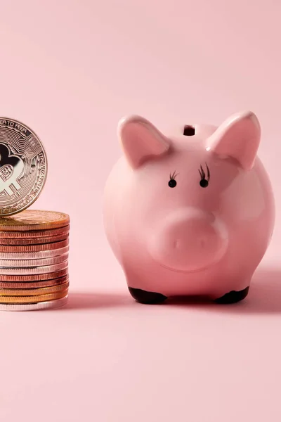 Nahaufnahme von Stapel Bitcoins und Sparschwein auf rosa Tischplatte — Stockfoto