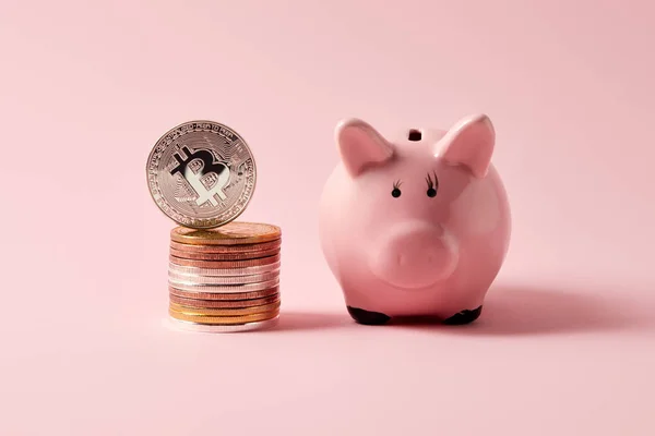 Stack of bitcoins and piggy bank on pink — Stock Photo