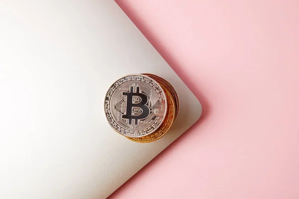 Vista superior de la pila de bitcoins en el ordenador portátil en rosa - foto de stock