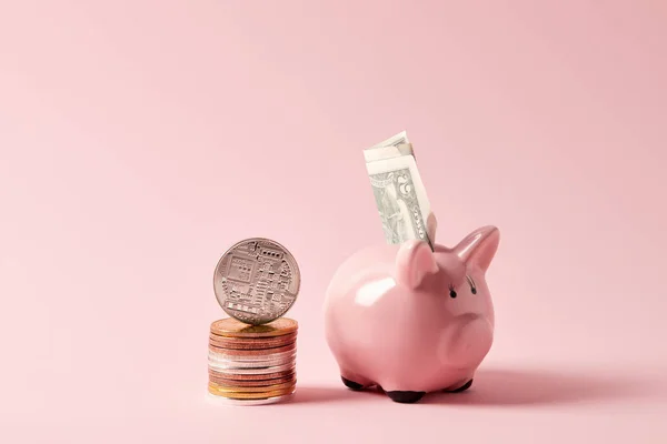 Stack of bitcoins and piggy bank with cash on pink — Stock Photo