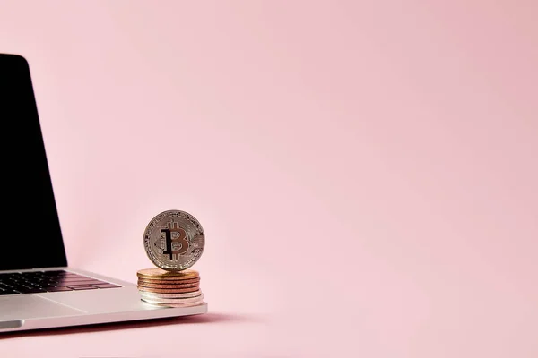 Bitcoins, складені один на ноутбук на рожевий поверхні — стокове фото