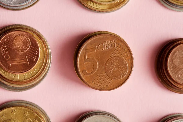 Vue de dessus des piles de diverses pièces sur rose — Photo de stock