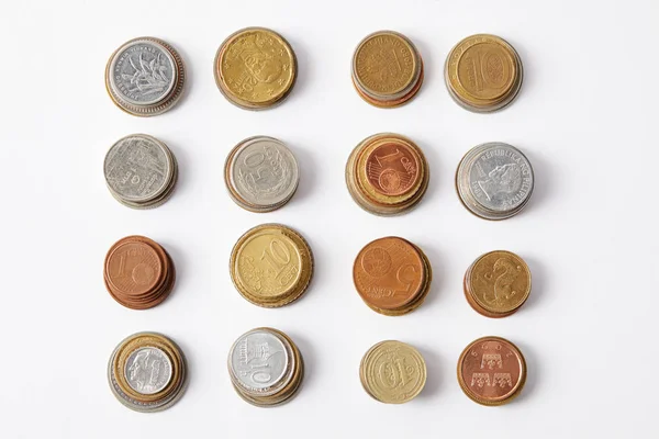 Верхний вид стопок различных монет на белом — стоковое фото