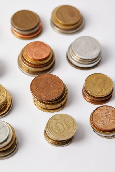 Close-up shot of stacks of different coins on white — Stock Photo