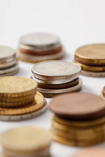 Close-up shot of stacks of coins on white — Stock Photo