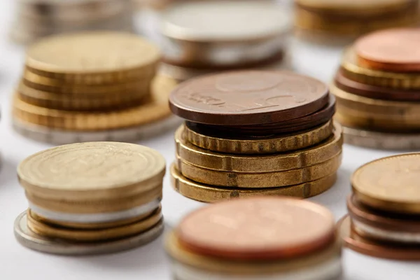 Close-up shot of stacks of coins from different countries on white — Stock Photo