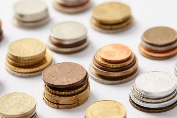 Gros plan des piles de pièces de divers pays sur blanc — Photo de stock